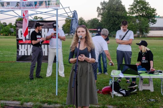 Вольга выступае на адным з пікетаў у падтрымку Святланы Ціханоўскай. Цяпер большасць людзей, якія трапілі ў кадр, пакараныя вялікімі турэмнымі тэрмінамі Вольга выступае на адным з пікетаў у падтрымку Святланы Ціханоўскай. Цяпер большасць людзей, якія трапілі ў кадр, пакараныя вялікімі турэмнымі тэрмінамі