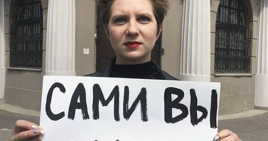 Актывістка выйшла да будынка МУС з плакатам «Самі вы падробка»