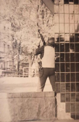 Міліцыянт страляе па снайперу. Калі я рабіў гэты фатаздымак, давялося вылезьці з укрыцьця, што дало натоўпу падставу рабіць змрочныя прадказаньні наконт майго лёсу. Міліцыянт страляе па снайперу. Калі я рабіў гэты фатаздымак, давялося вылезьці з укрыцьця, што дало натоўпу падставу рабіць змрочныя прадказаньні наконт майго лёсу.